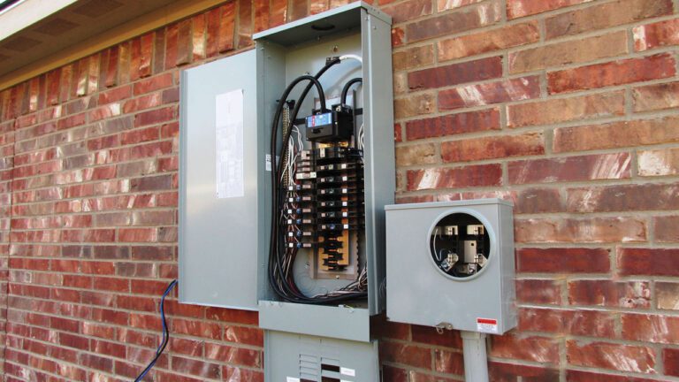 electrical-panel-open-on-the-side-of-a-brick-house
