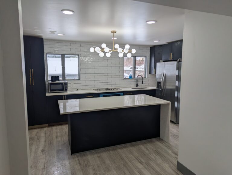remodeled-kitchen-with-marble-and-a-white-tile-backsplash