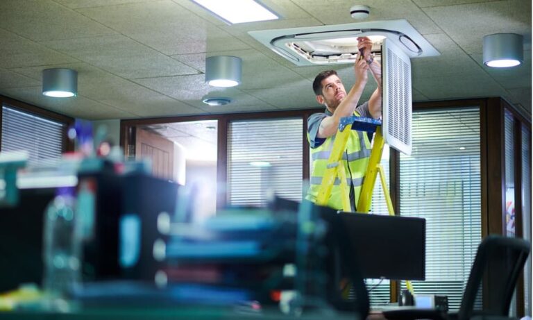 man-on-ladder-looking-up-installing-a-filter-in-commercial-building
