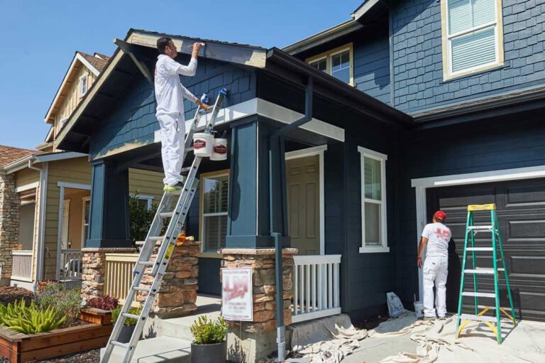 two-men-painting-a-house-dark-blue-doing-exterior-painting