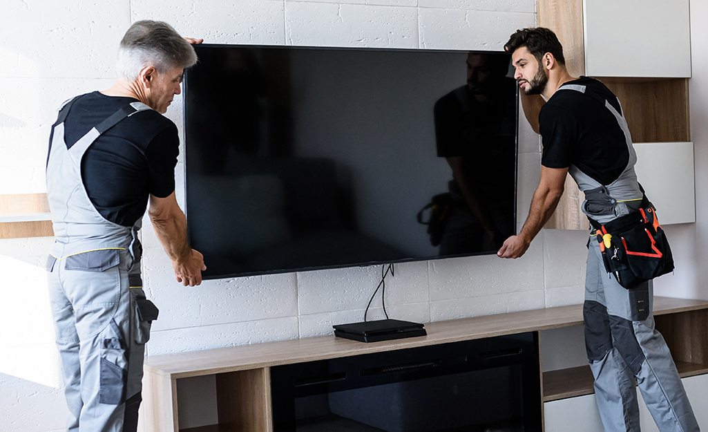 two-men-mounting-a-flat-screen-tv-on-the-wall