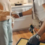 handyman and woman shaking hand with toolbox in view
